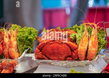 Grands crabes et crevettes royales avec salade verte de plats sur un stand de nourriture de rue Banque D'Images