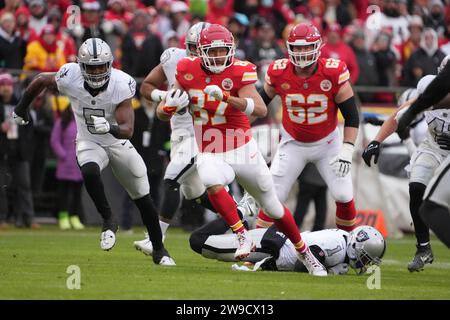 Kansas City Chiefs Tight End Travis Kelce (87) porte le ballon contre le linebacker Divine Deablo (5) des Raiders de Las Vegas lors d'un match de football de la NFL, lundi 25 décembre 2023, à Kansas City, Mo. Les Raiders ont battu les Chiefs 20-14. Banque D'Images