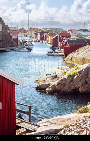 Hangars à bateaux et entrepôts aux façades en bois rouge et rochers de granit dans le port de Smögen dans l'archipel de la côte ouest suédoise Banque D'Images
