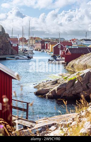 Hangars à bateaux et entrepôts aux façades en bois rouge et rochers de granit dans le port de Smögen dans l'archipel de la côte ouest suédoise Banque D'Images