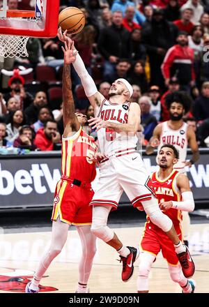 Chicago, États-Unis. 26 décembre 2023. Alex Caruso (C) des Bulls de Chicago monte au panier lors du match de saison régulière de la NBA entre les Hawks d’Atlanta et les Bulls de Chicago à Chicago, aux États-Unis, le 26 décembre 2023. Crédit : Joel Lerner/Xinhua/Alamy Live News Banque D'Images