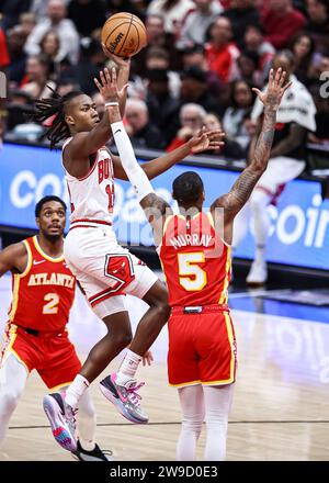 Chicago, États-Unis. 26 décembre 2023. Ayo Dosunmu (C) des Chicago Bulls monte au panier lors du match de saison régulière de la NBA entre les Hawks d'Atlanta et les Bulls de Chicago à Chicago, aux États-Unis, le 26 décembre 2023. Crédit : Joel Lerner/Xinhua/Alamy Live News Banque D'Images