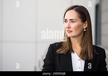 Femme d'affaires adulte vêtue en costume se tient dehors regardant loin Banque D'Images