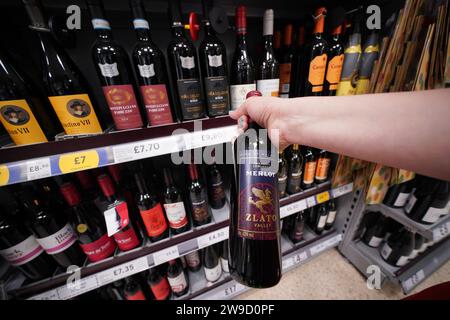 Photo de dossier datée du 03/09/22 d'un acheteur regardant du vin dans un supermarché Tesco à Londres. Les Britanniques seront bientôt en mesure d'acheter des bouteilles de vin plat et mousseux de la taille d'une pinte sous la forme d'une nouvelle quantité de 568 ml qui apparaîtra sur les étagères des supermarchés et dans les pubs, les clubs et les restaurants, a annoncé le gouvernement. La décision d'introduire la taille de 568 ml s'inscrira aux côtés des mesures de 200 ml et 500 ml déjà disponibles, offrant plus de flexibilité et de choix pour les clients, a déclaré le ministère des Affaires et du Commerce. Date de publication : mercredi 27 décembre 2023. Banque D'Images