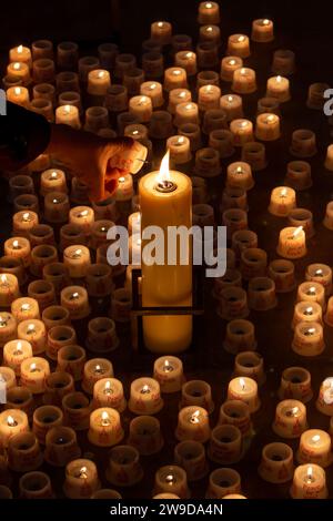 Une personne allumant une bougie dans une église. Photo de haute qualité. Gros plan Banque D'Images