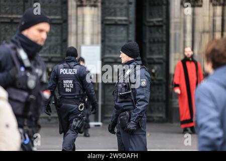 Cologne, Allemagne. 27 décembre 2023. Des policiers se tiennent devant la cathédrale. La cathédrale de Cologne reste fermée aux visiteurs après l'alerte terroriste. Crédit : Oliver Berg/dpa/Alamy Live News Banque D'Images