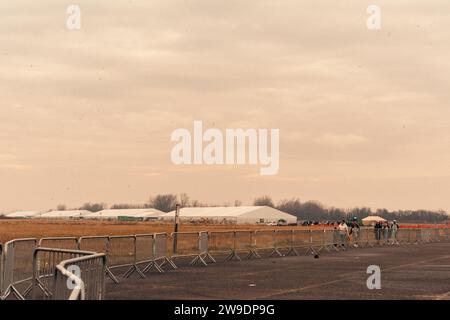 Brooklyn, États-Unis. 24 décembre 2023. Des migrants nouvellement arrivés du Venezuela sont vus à l’extérieur de leur hébergement à Floyd Bennett Field dans Marine Park, Brooklyn, NY, le dimanche 24 décembre, 2023.le Bureau de la gestion des situations d’urgence a érigé quatre tentes sur le terrain de Floyd Bennett afin de fournir un abri à 2 000 des plus de 150 000 migrants arrivés à New York depuis le printemps 2022. (Photo de Cristina Matuozzi/Sipa USA) crédit : SIPA USA/Alamy Live News Banque D'Images