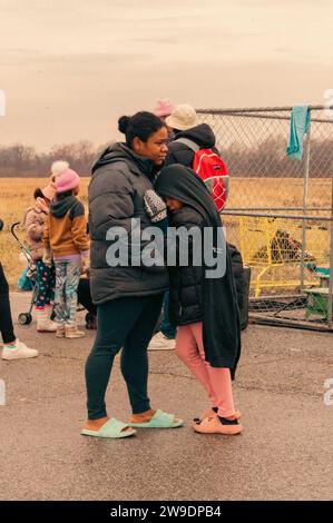 Brooklyn, États-Unis. 24 décembre 2023. Des migrants nouvellement arrivés du Venezuela sont vus à l’extérieur de leur hébergement à Floyd Bennett Field dans Marine Park, Brooklyn, NY, le dimanche 24 décembre, 2023.le Bureau de la gestion des situations d’urgence a érigé quatre tentes sur le terrain de Floyd Bennett afin de fournir un abri à 2 000 des plus de 150 000 migrants arrivés à New York depuis le printemps 2022. (Photo de Cristina Matuozzi/Sipa USA) crédit : SIPA USA/Alamy Live News Banque D'Images