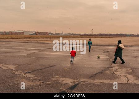 Brooklyn, États-Unis. 24 décembre 2023. Des migrants nouvellement arrivés du Venezuela sont vus à l’extérieur de leur hébergement à Floyd Bennett Field dans Marine Park, Brooklyn, NY, le dimanche 24 décembre, 2023.le Bureau de la gestion des situations d’urgence a érigé quatre tentes sur le terrain de Floyd Bennett afin de fournir un abri à 2 000 des plus de 150 000 migrants arrivés à New York depuis le printemps 2022. (Photo de Cristina Matuozzi/Sipa USA) crédit : SIPA USA/Alamy Live News Banque D'Images