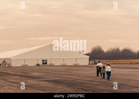 Brooklyn, États-Unis. 24 décembre 2023. Des migrants nouvellement arrivés du Venezuela sont vus à l’extérieur de leur hébergement à Floyd Bennett Field dans Marine Park, Brooklyn, NY, le dimanche 24 décembre, 2023.le Bureau de la gestion des situations d’urgence a érigé quatre tentes sur le terrain de Floyd Bennett afin de fournir un abri à 2 000 des plus de 150 000 migrants arrivés à New York depuis le printemps 2022. (Photo de Cristina Matuozzi/Sipa USA) crédit : SIPA USA/Alamy Live News Banque D'Images