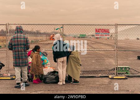 Brooklyn, États-Unis. 24 décembre 2023. Des migrants nouvellement arrivés du Venezuela sont vus à l’extérieur de leur hébergement à Floyd Bennett Field dans Marine Park, Brooklyn, NY, le dimanche 24 décembre, 2023.le Bureau de la gestion des situations d’urgence a érigé quatre tentes sur le terrain de Floyd Bennett afin de fournir un abri à 2 000 des plus de 150 000 migrants arrivés à New York depuis le printemps 2022. (Photo de Cristina Matuozzi/Sipa USA) crédit : SIPA USA/Alamy Live News Banque D'Images