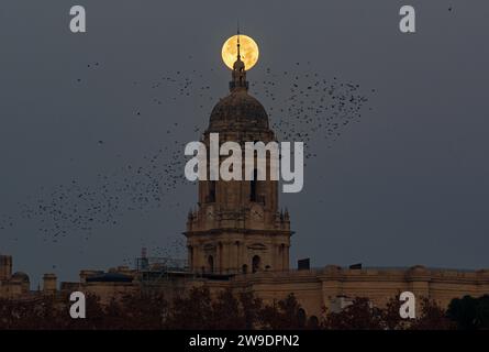 Malaga, Espagne. 27 décembre 2023. La pleine lune de décembre, connue sous le nom de «lune froide», est vue dans le ciel au sommet de la cathédrale de Malaga. En décembre a lieu la dernière pleine lune de l'année et la première de l'hiver, appelée la lune froide en raison des températures froides de l'hiver dans l'hémisphère nord. (Photo Jesus Merida/SOPA Images/Sipa USA) crédit : SIPA USA/Alamy Live News Banque D'Images