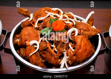 Savoureux plat de curry de poulet beurre de cuisine indienne au buffet, décorations Orange Slice. Banque D'Images