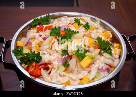 Salade avec radis, tomates et pomme sur une assiette en buffet. Banque D'Images