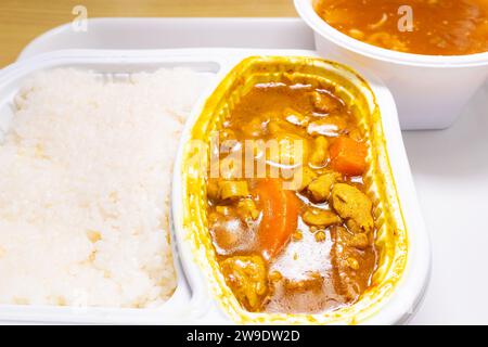 vue d'angle poulet au curry avec riz et bol de soupe aromatisée aux œufs de crabe à composition horizontale Banque D'Images