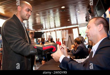 8 SEPT. 2013 - ST. LOUIS -- le grand maître d'échecs américain Gata Kamsky (à droite) signe des gants de boxe par Geor, membre de l'équipe d'échecs de l'Université Lindenwood Banque D'Images