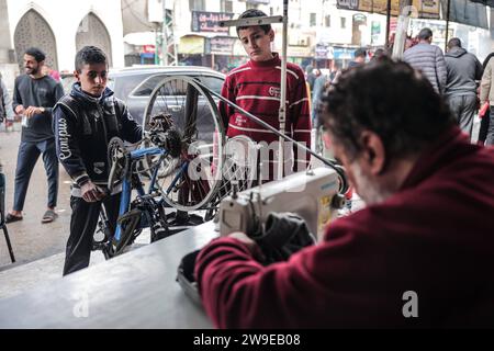 Un tailleur palestinien nommé Abu Adam Dolah utilise une machine à coudre pédalée qu’il a développée en raison d’une pénurie d’électricité Un tailleur palestinien nommé Abu Adam Dolah utilise une machine à coudre pédalée qu’il a développée en raison d’une pénurie d’électricité alors qu’Israël continue de bloquer l’électricité à Rafah, Gaza, le 27 décembre 2023. Gashda a attaché des pédales de vélo à sa machine à coudre d'une manière qui lui permet d'utiliser la machine sans électricité. Photo de Bashar Taleb apaimages Rafah bande de Gaza territoire palestinien 271223 Rafah BT 0019 Copyright : xapaimagesxBasharxTalebxapaimagesx Banque D'Images