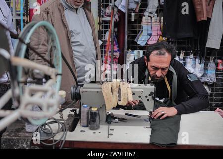 Un tailleur palestinien nommé Abu Adam Dolah utilise une machine à coudre pédalée qu’il a développée en raison d’une pénurie d’électricité Un tailleur palestinien nommé Abu Adam Dolah utilise une machine à coudre pédalée qu’il a développée en raison d’une pénurie d’électricité alors qu’Israël continue de bloquer l’électricité à Rafah, Gaza, le 27 décembre 2023. Gashda a attaché des pédales de vélo à sa machine à coudre d'une manière qui lui permet d'utiliser la machine sans électricité. Photo de Bashar Taleb apaimages Rafah bande de Gaza territoire palestinien 271223 Rafah BT 009 Copyright : xapaimagesxBasharxTalebxapaimagesx Banque D'Images