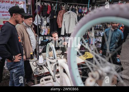 Un tailleur palestinien nommé Abu Adam Dolah utilise une machine à coudre pédalée qu’il a développée en raison d’une pénurie d’électricité Un tailleur palestinien nommé Abu Adam Dolah utilise une machine à coudre pédalée qu’il a développée en raison d’une pénurie d’électricité alors qu’Israël continue de bloquer l’électricité à Rafah, Gaza, le 27 décembre 2023. Gashda a attaché des pédales de vélo à sa machine à coudre d'une manière qui lui permet d'utiliser la machine sans électricité. Photo de Bashar Taleb apaimages Rafah bande de Gaza territoire palestinien 271223 Rafah BT 006 Copyright : xapaimagesxBasharxTalebxapaimagesx Banque D'Images