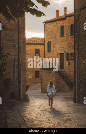 Une jeune touriste blonde explore les ruelles du pittoresque et charmant village toscan Monticchiello, Toscane, Italie. Banque D'Images