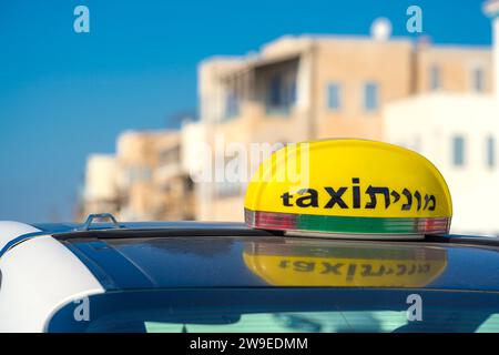 Taxi en Israël. Une étiquette jaune sur le dessus d'un véhicule avec le mot taxi en anglais et en hébreu Banque D'Images