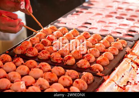 Le takoyaki est un aliment japonais à base de farine de blé et de poulpe. Il est fait en forme de boule. Banque D'Images