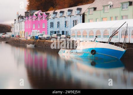 Un bateau de pêche submergé dans le port à marée haute dans le village balnéaire coloré de Portree, île de Skye, Écosse, Royaume-Uni en automne. Banque D'Images