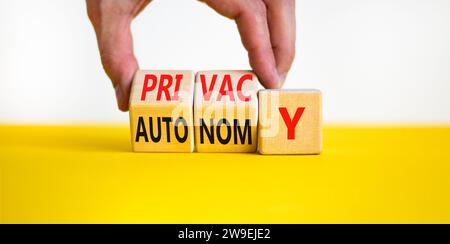 Symbole de confidentialité ou d'autonomie. Mot concept vie privée ou autonomie sur cubes en bois. Belle table jaune fond blanc. Main d'homme d'affaires. Entreprise priv Banque D'Images