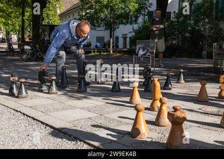 Hommes seniors jouant aux échecs avec de grandes pièces d'échecs dans le parc, Zurich, Suisse Banque D'Images