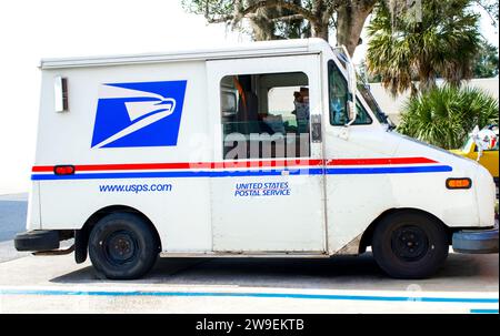 Ocala, Floride, États-Unis 2 novembre 2023 USPS camion livrant du courrier sur une rue de banlieue garée dans un espace occupé. Couleurs concept rouge blanc et bleu avec am Banque D'Images