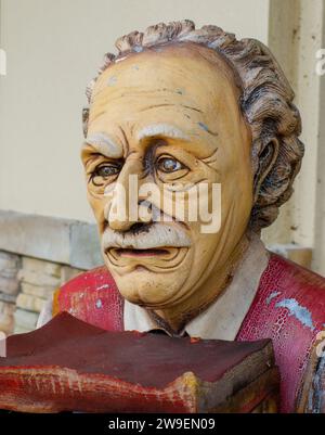 Rare buste de statue vintage du célèbre scientifique Albert Einstein tenant une pile de livres, gros plan du visage. Résine de fibre de verre montrant des fissures et des signes Banque D'Images