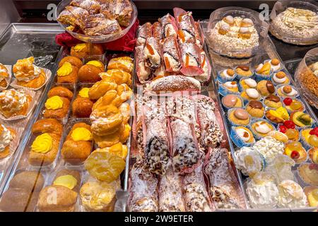 Viennoiseries italiennes exposées dans le comptoir, pâtisseries farcies à la crème et au chocolat, cannoli siciliens et gâteaux à la crème Banque D'Images