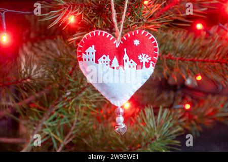 Artisanat maison a senti décorations d'arbre de Noël sur un arbre avec des lumières, une scène de neige rouge et blanche en forme de coeur Banque D'Images