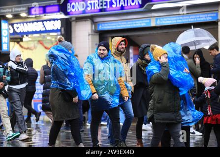 Londres, Royaume-Uni, 27 décembre 2023. Les acheteurs ont bravé les rafales de vent et les fortes averses de pluie de la tempête Gerrit sur Oxford Street, tandis que les ventes du lendemain de Noël se poursuivaient. Malgré la tempête, les températures restent exceptionnellement douces. Crédit : Monica Wells/Alamy Live News Banque D'Images