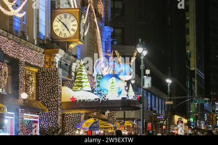 New York City, New York, USA - 3 décembre 2022 : une rue animée avec des lumières de noël et des décorations accrochées au bâtiment Macy. Banque D'Images