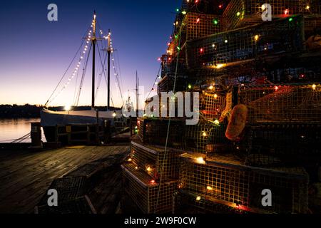 Décoration figurative d'arbre de Noël construite à partir de pièges à homard à côté d'une goélette de pêche historique sur le front de mer à Lunenburg, en Nouvelle-Écosse. Banque D'Images