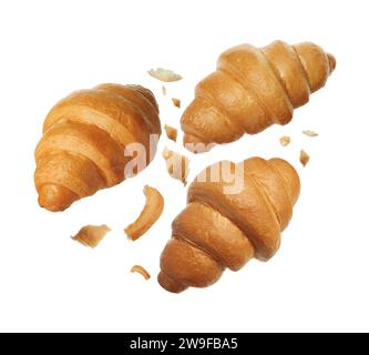 Délicieux croissants frais tombant sur fond blanc Banque D'Images