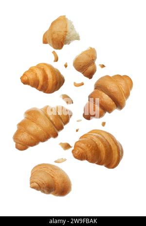 Délicieux croissants frais tombant sur fond blanc Banque D'Images