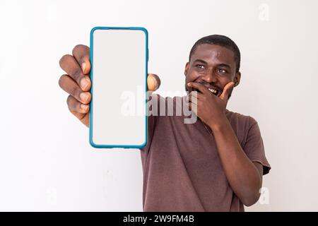 Le gars afro-américain noir débordé tenant un grand smartphone avec un écran blanc blanc en main, Banque D'Images