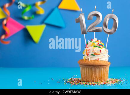Gâteau d'anniversaire avec bougie numéro 120 - fond bleu Banque D'Images
