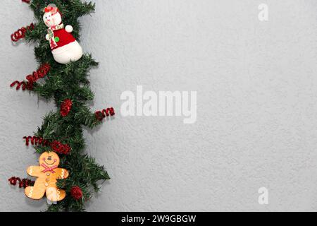 Père Noël, bonhomme de neige et biscuit de pain d'épice dans la couronne de noël avec fond gris, décoration de noël Banque D'Images