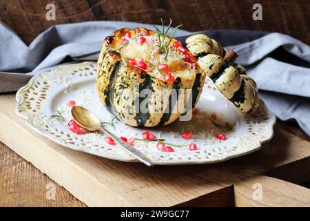 Risotto à la citrouille servi dans une citrouille creuse. Citrouille cuite au four avec du fromage et des graines de grenade. Banque D'Images