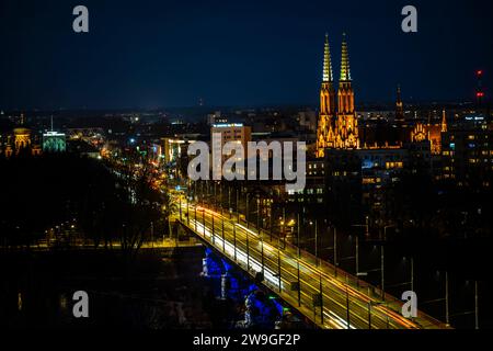 Varsovie, Pologne - 27 décembre 2023 : vue de nuit sur le pont Slasko-Dabrowski et la cathédrale de St. Michel l'Archange et St. Florian le Martyr. Banque D'Images