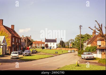 Voitures garées à l'extérieur des maisons autour de village Green, Walberswick, Suffolk, Angleterre, Royaume-Uni juin 1975 Banque D'Images