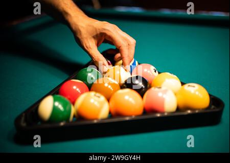 Joueur de billard mettant des balles dans le triangle Banque D'Images