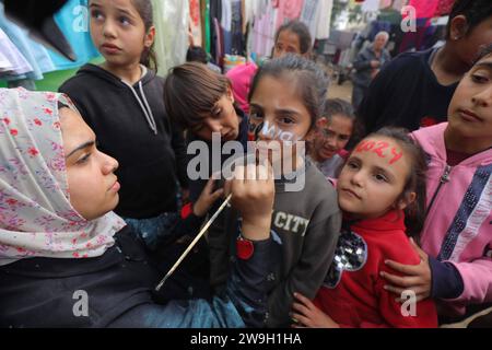 L’artiste palestinienne Menna Allah Hamouda, 20 ans, dessine 2024 ans et expressions appelant à la fin de la guerre les visages des enfants déplacés l’artiste palestinienne Menna Allah Hamouda, 20 ans, tire 2024 et expressions appelant à la fin de la guerre sur le visage des enfants déplacés avant les célébrations du nouvel an dans une école de l UNRWA à Deir Balah, dans le centre de la bande de Gaza, le 28 décembre 2023. Photo Omar Ashtawy apaimages Dair El-Balah bande de Gaza territoire palestinien 271223 Dair El-Balah OSH 0010 Copyright : xapaimagesxOmarxAshtawyxxapaimagesx Banque D'Images