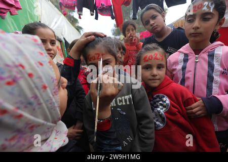 L’artiste palestinienne Menna Allah Hamouda, 20 ans, dessine 2024 ans et expressions appelant à la fin de la guerre les visages des enfants déplacés l’artiste palestinienne Menna Allah Hamouda, 20 ans, tire 2024 et expressions appelant à la fin de la guerre sur le visage des enfants déplacés avant les célébrations du nouvel an dans une école de l UNRWA à Deir Balah, dans le centre de la bande de Gaza, le 28 décembre 2023. Photo Omar Ashtawy apaimages Dair El-Balah bande de Gaza territoire palestinien 271223 Dair El-Balah OSH 0015 Copyright : xapaimagesxOmarxAshtawyxxapaimagesx Banque D'Images