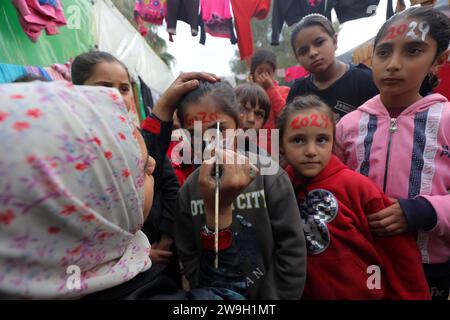 L’artiste palestinienne Menna Allah Hamouda, 20 ans, dessine 2024 ans et expressions appelant à la fin de la guerre les visages des enfants déplacés l’artiste palestinienne Menna Allah Hamouda, 20 ans, tire 2024 et expressions appelant à la fin de la guerre sur le visage des enfants déplacés avant les célébrations du nouvel an dans une école de l UNRWA à Deir Balah, dans le centre de la bande de Gaza, le 28 décembre 2023. Photo Omar Ashtawy apaimages Dair El-Balah bande de Gaza territoire palestinien 271223 Dair El-Balah OSH 0017 Copyright : xapaimagesxOmarxAshtawyxxapaimagesx Banque D'Images