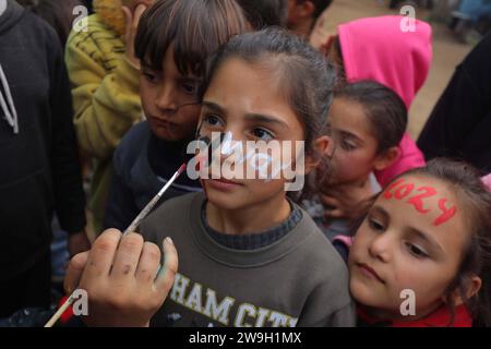 L’artiste palestinienne Menna Allah Hamouda, 20 ans, dessine 2024 ans et expressions appelant à la fin de la guerre les visages des enfants déplacés l’artiste palestinienne Menna Allah Hamouda, 20 ans, tire 2024 et expressions appelant à la fin de la guerre sur le visage des enfants déplacés avant les célébrations du nouvel an dans une école de l UNRWA à Deir Balah, dans le centre de la bande de Gaza, le 28 décembre 2023. Photo Omar Ashtawy apaimages Dair El-Balah bande de Gaza territoire palestinien 271223 Dair El-Balah OSH 0013 Copyright : xapaimagesxOmarxAshtawyxxapaimagesx Banque D'Images