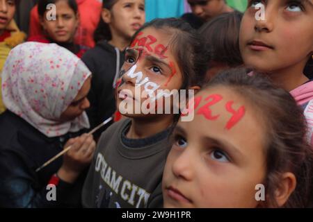 L’artiste palestinienne Menna Allah Hamouda, 20 ans, dessine 2024 ans et expressions appelant à la fin de la guerre les visages des enfants déplacés l’artiste palestinienne Menna Allah Hamouda, 20 ans, tire 2024 et expressions appelant à la fin de la guerre sur le visage des enfants déplacés avant les célébrations du nouvel an dans une école de l UNRWA à Deir Balah, dans le centre de la bande de Gaza, le 28 décembre 2023. Photo Omar Ashtawy apaimages Dair El-Balah bande de Gaza territoire palestinien 271223 Dair El-Balah OSH 0027 Copyright : xapaimagesxOmarxAshtawyxxapaimagesx Banque D'Images